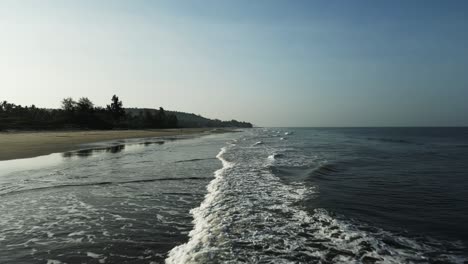 Aerial-shot-of-waves-approaching-the-beach-in-the-morning