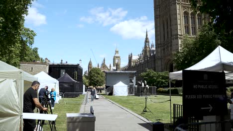 Carpas-De-Prensa-Instaladas-En-Los-Jardines-De-Abingdon-Street,-Cerca-De-Westminster,-Con-Equipos-De-Cámara-Y-El-Big-Ben-Visibles-Al-Fondo.