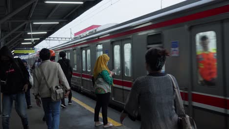 Gente-Esperando-En-La-Estación-De-Tren-Rawa-Buntu-Mientras-Pasa-Un-Tren-De-Cercanías-En-Tangerang-Selatan.