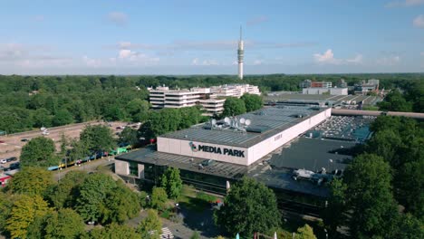 Drone-footage-offers-an-aerial-overview-of-Media-Park-in-Hilversum,-highlighting-broadcasting-buildings,-satellite-dishes,-and-the-TV-radio-tower