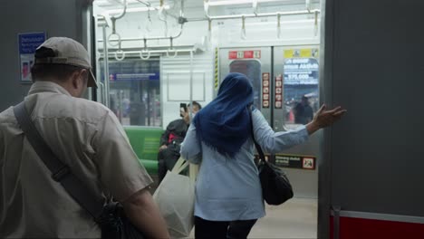 Frau-Steigt-Am-Bahnhof-Swamp-Untu-In-Süd-Tangerang,-Indonesien,-In-Den-Zug-Ein,-Innenansicht