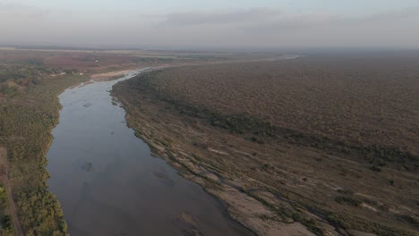 Drohnenansicht-Des-Saisonalen-Oder-Kurzlebigen-Krokodilflusses-Durch-Ackerland-Am-Rande-Des-Berühmten-Krüger-Nationalparks