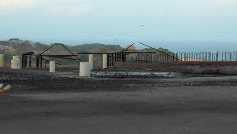 Wide-shot-from-abandoned-Concrete-construction-ruins-reveals-a-dramatic-coast-at-sunset