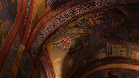 View-Looking-Up-At-beautifully-detailed-religious-mural,-illustrating-saints-and-various-religious-scenes-with-vibrant-colors-and-intricate-designs-on-a-domed-ceiling