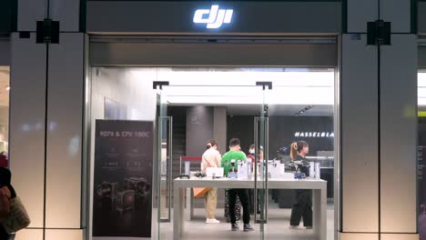 Los-Clientes-Compran-En-La-Tienda-Oficial-De-La-Empresa-De-Tecnología-China-DJI,-Conocida-Por-Su-Línea-De-Productos-De-Drones,-Durante-La-Noche-En-Hong-Kong.