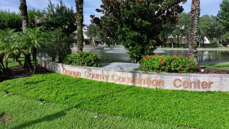 Menschen,-Die-Am-Schild-Des-Orange-County-Convention-Center-In-Orlando,-Florida-Vorbeigehen