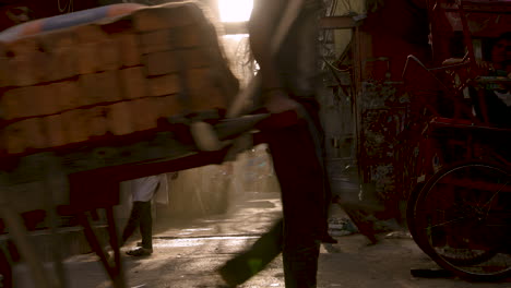 Man-sweeping-trash-on-small-street-in-Old-Delhi,-India