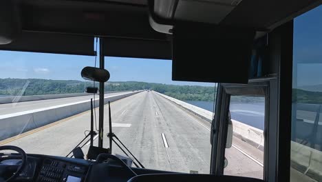 4K-footage-from-the-front-window-of-a-bus-crossing-the-Susquehanna-River,-there-are-three-lines-and-not-many-cars,-it's-early-summer-and-the-wide-river-is-visible-as-well-as-the-forest-ahead