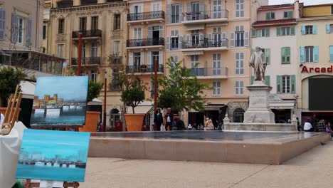 Vista-De-La-Calle-De-Cannes-Con-Estatua-Y-Movimiento-Borroso-De-Personas-Que-Pasan