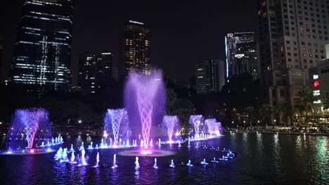 Lila-Und-Rot-Wassershow-In-Den-KLCC-Petronas-Twin-Towers-Mit-Der-Skyline-Von-Kuala-Lumpur-Im-Hintergrund,-Malaysia