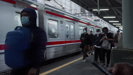 Commuters-wearing-masks-walk-at-Rawa-Buntu-Train-Station-in-Tangerang-Selatan,-Indonesia