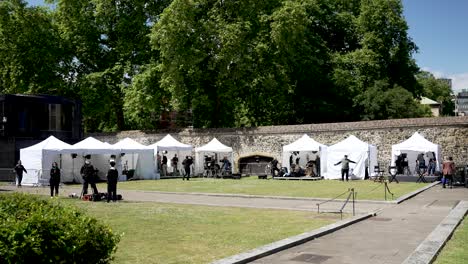 Journalists-preparing-their-equipment-in-a-press-area-with-tents,-getting-ready-to-report-live-from-abingdon-street-gardens,-westminster