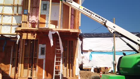 Gimbal-Weitschwenkaufnahme-Eines-Bauarbeiters-Auf-Der-Spitze-Eines-Hebekrans-Auf-Einer-Baustelle-In-West-Los-Angeles,-Kalifornien