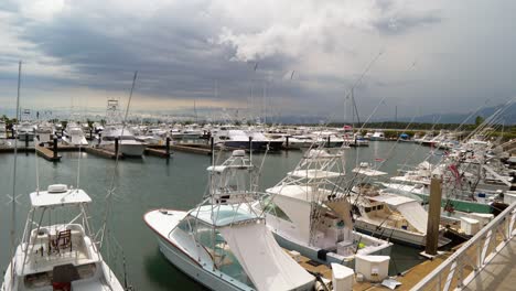 Timelapse-Desde-La-Marina-Pez-Vela-Con-Barcos-De-Pesca-Deportiva-Atracados-Y-Yates-Más-Pequeños-En-Un-Día-Tormentoso-En-Quepos,-Costa-Rica