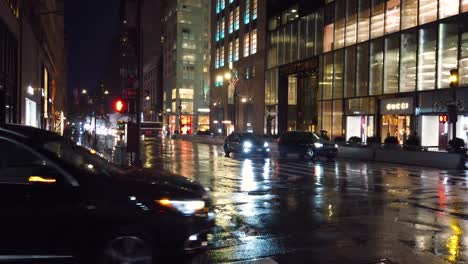 Toma-De-Autos-Esperando-Que-Cambie-El-Semáforo-En-La-Intersección-De-La-Quinta-Avenida-Y-La-Calle-56-Durante-La-Lluvia-De-Una-Noche-En-La-Ciudad-De-Nueva-York.