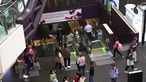 Shoppers-and-commuters-taking-the-escalators-up-and-down-at-Melbourne-Central-Station,-a-shopping-and-commercial-precinct-in-the-cit-center,-showcasing-hustle-and-bustle-of-urban-lifestyle