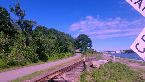 Narrow-guage-railroad-crossing-sign-on-trail-in-Portland,-Maine