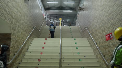 People-at-Sudimara-Train-Station,-Tangerang-Selatan,-using-the-stairs-and-walking-around