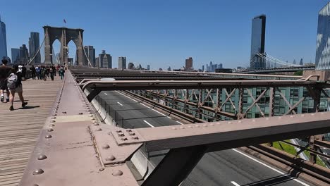 Coches-Circulando-Uno-Al-Lado-Del-Otro-Y-Algunas-Personas-Caminando-Más-Lejos-En-El-Puente-De-Brooklyn.