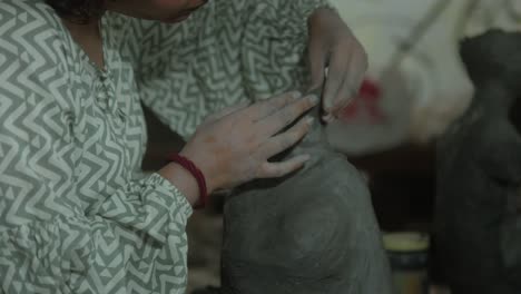 Person-shaping-clay-sculpture-in-studio-with-detailed-hands-on-technique