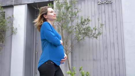 Happy-confident-pregnant-caucasian-woman-walking-down-street