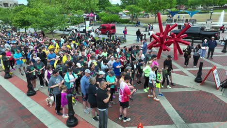 Aerial-view-showing-crowd-of-hobby-runners-starting-in-american-town