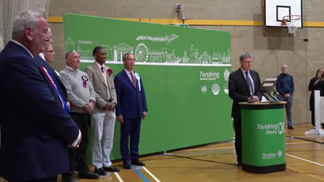 Nigel-Farage-and-other-candidates-line-up-for-the-general-election-vote-result-announcement-in-Clacton-on-Sea,-Essex,-UK