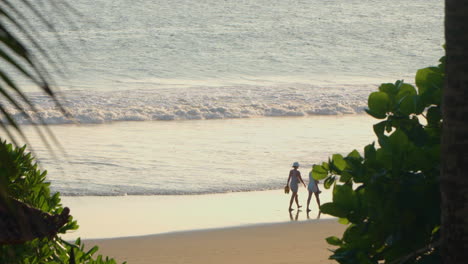 Dos-Mujeres-Turistas-Caminando-Junto-Al-Mar-En-La-Playa-De-Semiyak,-Bali---Cámara-Lenta,-Gran-Angular