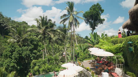 Tourists-Enjoying-Balinese-Vacation-Surrounded-With-Tropical-Jungles-in-Tis-Cafe,-Ubud-on-Sunny-Day---Pan-Reveal