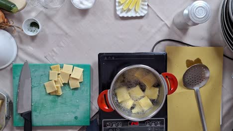 Panelle-or-Panella-chickpea-fritters-fried-in-pot-with-oil-as-chef-checks-temperature-infrared-sensor