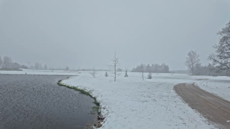 Un-Dron-Sobrevuela-Un-Lago,-Capturando-La-Belleza-De-Un-Paisaje-Cubierto-De-Nieve