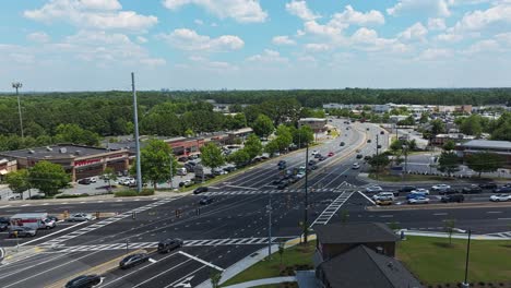 Panorama-view-of-american-highway-with-driving-cars-and-Shopping-mall-in-Background