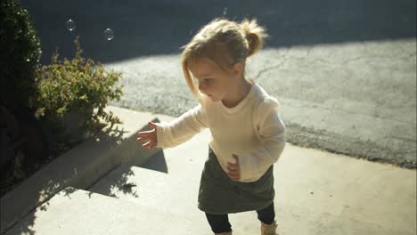 Happy-little-girl-playing-with-bubbles-at-halloween-pumpkin-patch