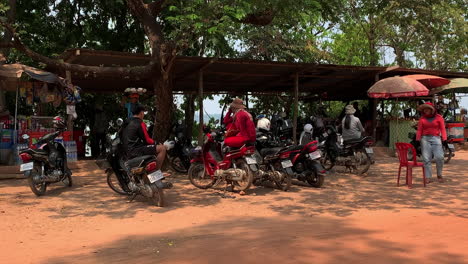 Relaxing-on-a-hot-day-at-a-motorcycle-pit-stop,-wide-shot