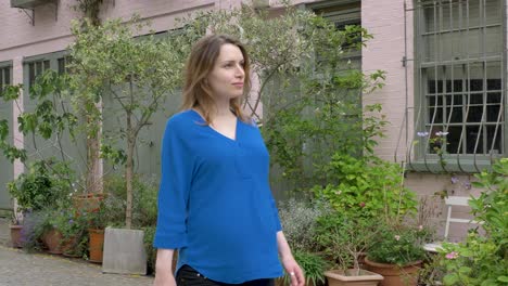 Happy-pregnant-caucasian-woman-walking-down-mews-street-in-London