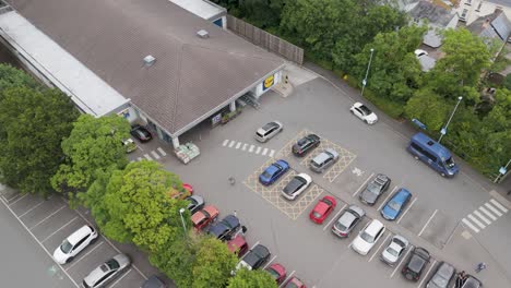 Drone-view-of-Lidl-supermarket-and-its-surrounding-carpark-in-Okehampton,-Devon,-UK,-captured-in-July-2024