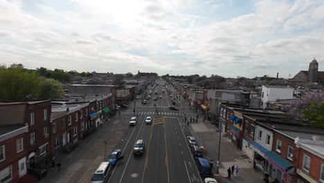 Main-street-of-american-town-with-driving-cars-on-road-during-sunny-day