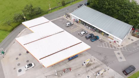 Top-down-view-of-Shell-petrol-station-in-Devon-UK,-showing-the-forecourt,-building,-and-surrounding-area,-July-2024