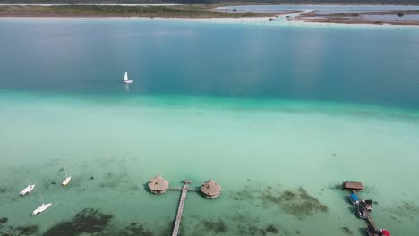 Aerial-view-approaching-a-sailboat-on-the-laguna-Bacalar,-in-Mexico---drone-shot