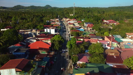 Drone-Volando-Sobre-Una-Carretera-En-Medio-De-Casas,-Hora-Dorada-En-Laguna,-Filipinas