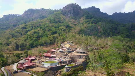 Aerial-view-of-"Watu-Putih"-tourist-attraction-with-hills-on-the-backrgound