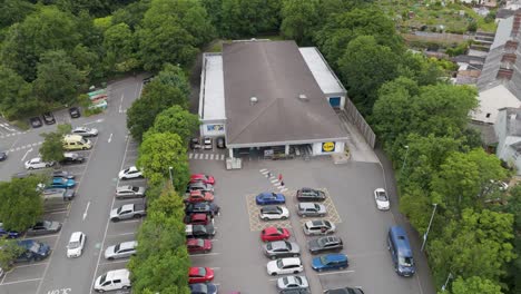 Drone-view-of-the-exterior-entrance-of-Lidl-supermarket-in-Okehampton,-Devon,-UK,-captured-in-July-2024