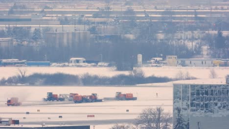 Uno-Tras-Otro,-Más-Colocadores-De-Pistas-De-Nieve-Trabajan-En-Un-Punto-Final-Público-Del-Aeropuerto.