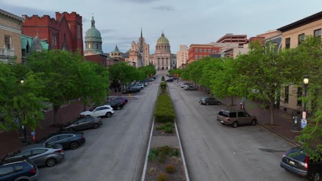 Ascending-drone-shot-of-parking-cars-and-famous-Pennsylvania-State-Capitol-in-background