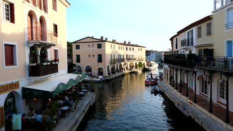 Historic-Buildings-with-dining-tourist-in-restaurant-between-channel-in-Port-Grimaud,-France