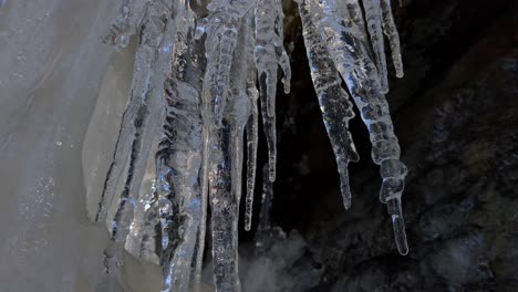 Ice-melting-slowly,-icicle-with-water-drops-close-up-in-nature,-global-warming-effect