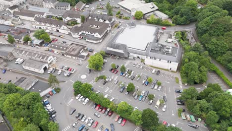 Aerial-exterior-view-of-Waitrose-supermarket-in-Okehampton-Devon-UK,-with-parking-lot-and-nearby-roads,-July-2024