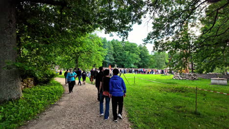 People-gather-on-grass-at-open-air-museum-talking-and-celebrating-during-the-midsummer-festival