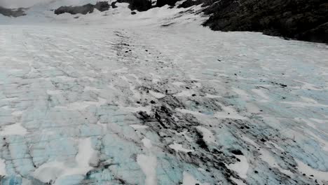 Areial-long-shot-of-man-crossing-Brewster-glacier-solo-in-remote-alpine-region-of-New-Zealand's-Souther-Alps-mountain-range