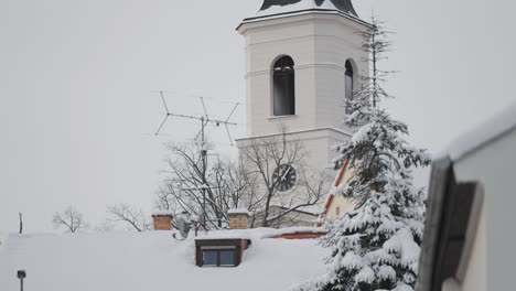 El-Campanario-De-Una-Iglesia-Cubierto-De-Nieve-Y-Rodeado-De-Edificios-Residenciales-En-Un-Barrio-Tranquilo-De-Praga.